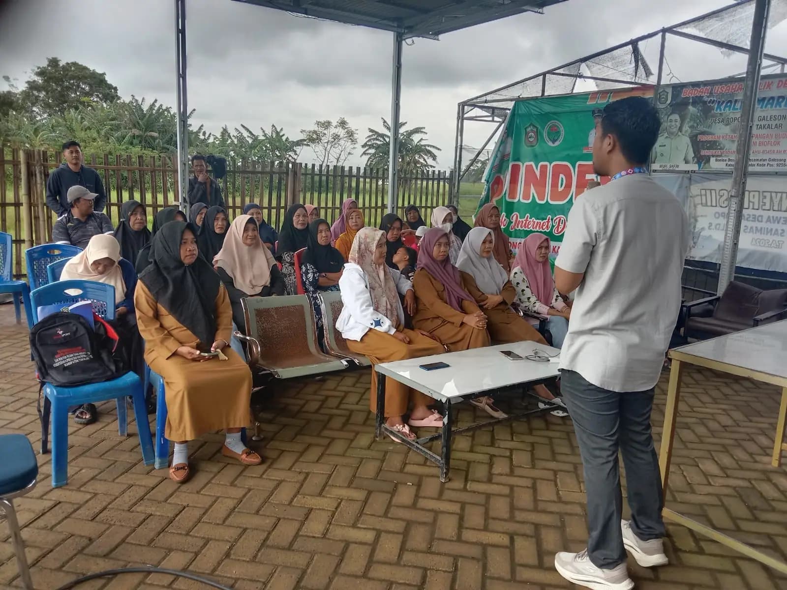 Sosialisasi pemanfaatan AI untuk usaha mikro di halaman kantor desa.